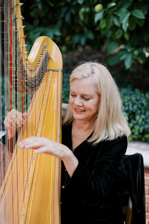 Peggy playing harp during an outdoor wedding ceremony