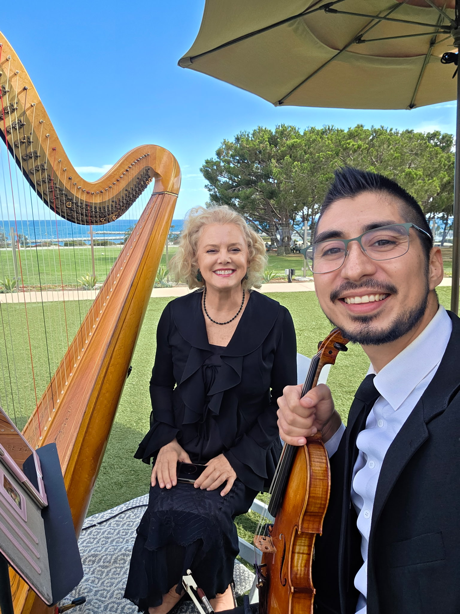 Harpist And Violinist Smiling Together After An Outdoor Event