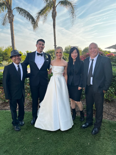 Bride and groom with a piano, violin and cello trio after an outdoor wedding ceremony