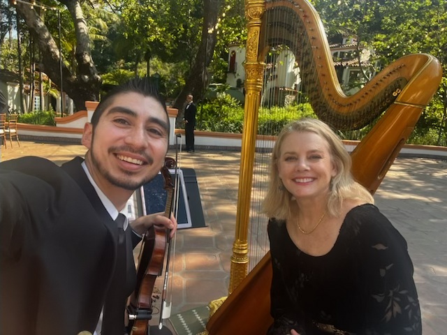 Violinist And Harpist Smiling At An Outdoor Event