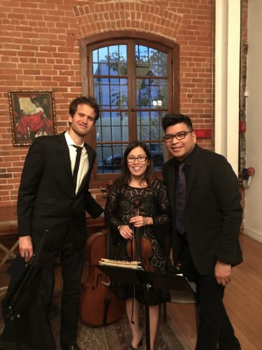 Cecile performing violin with musicians at an elegant live event