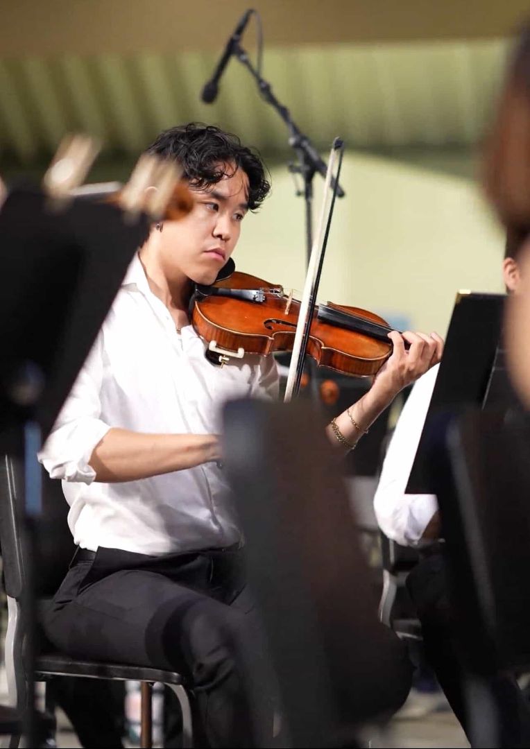 Gabe performing live violin in an orchestra setting