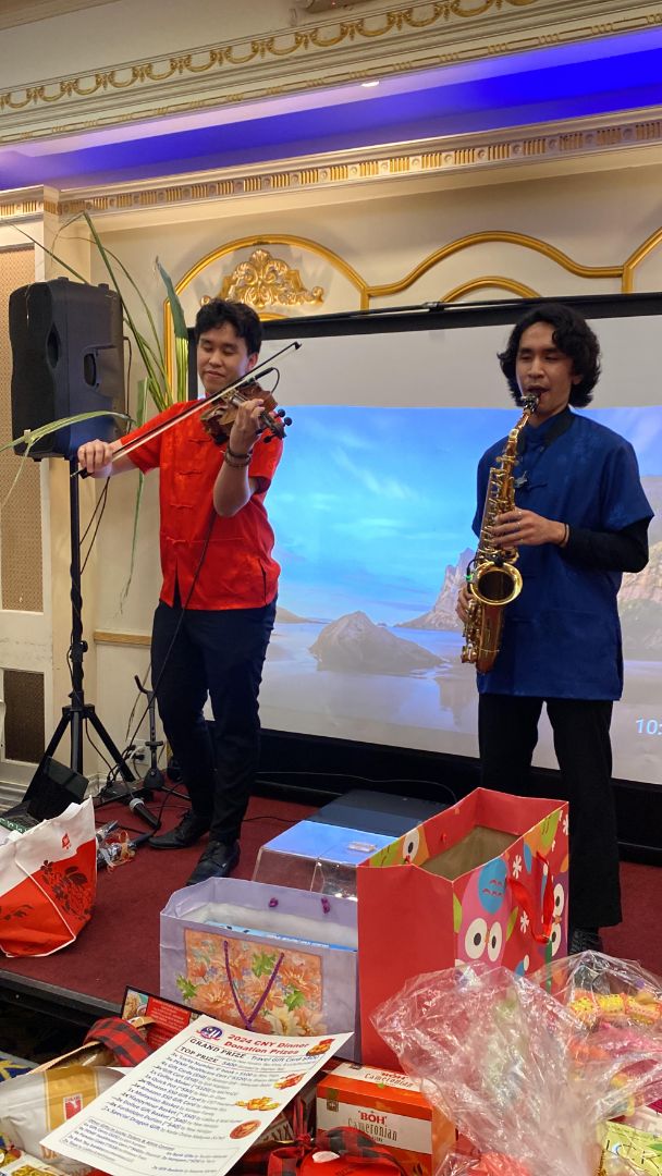 De Leon Brothers violin and sax duo performing live at an event