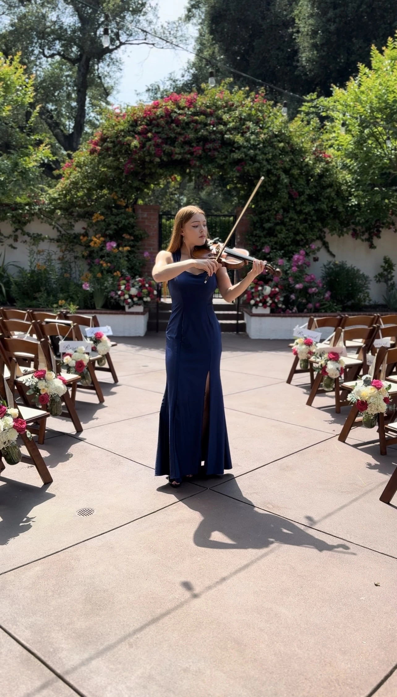 Katie performing live violin music during an outdoor wedding ceremony