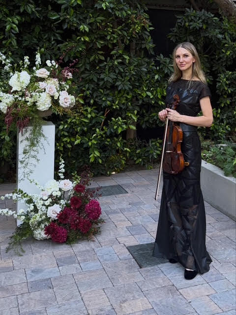 Mila performing violin music at an elegant garden event