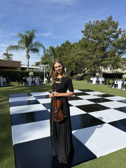 Mila performing violin music at an outdoor wedding venue in Los Angeles