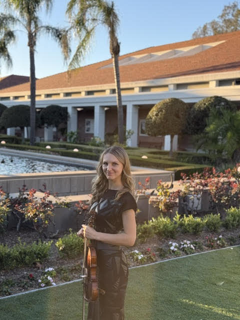 Golden hour portrait of Mila holding her violin outdoors