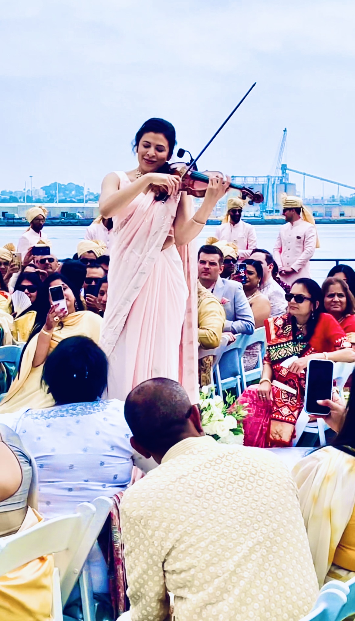 Priyanka posing with violin during a formal charity gala event