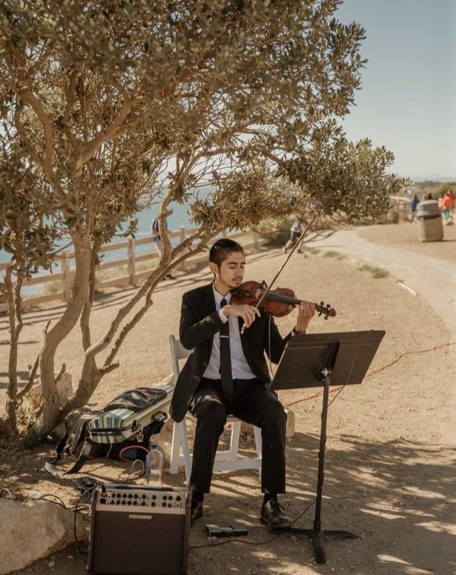 Solo wedding violinist performing ceremony music at an ocean view wedding venue