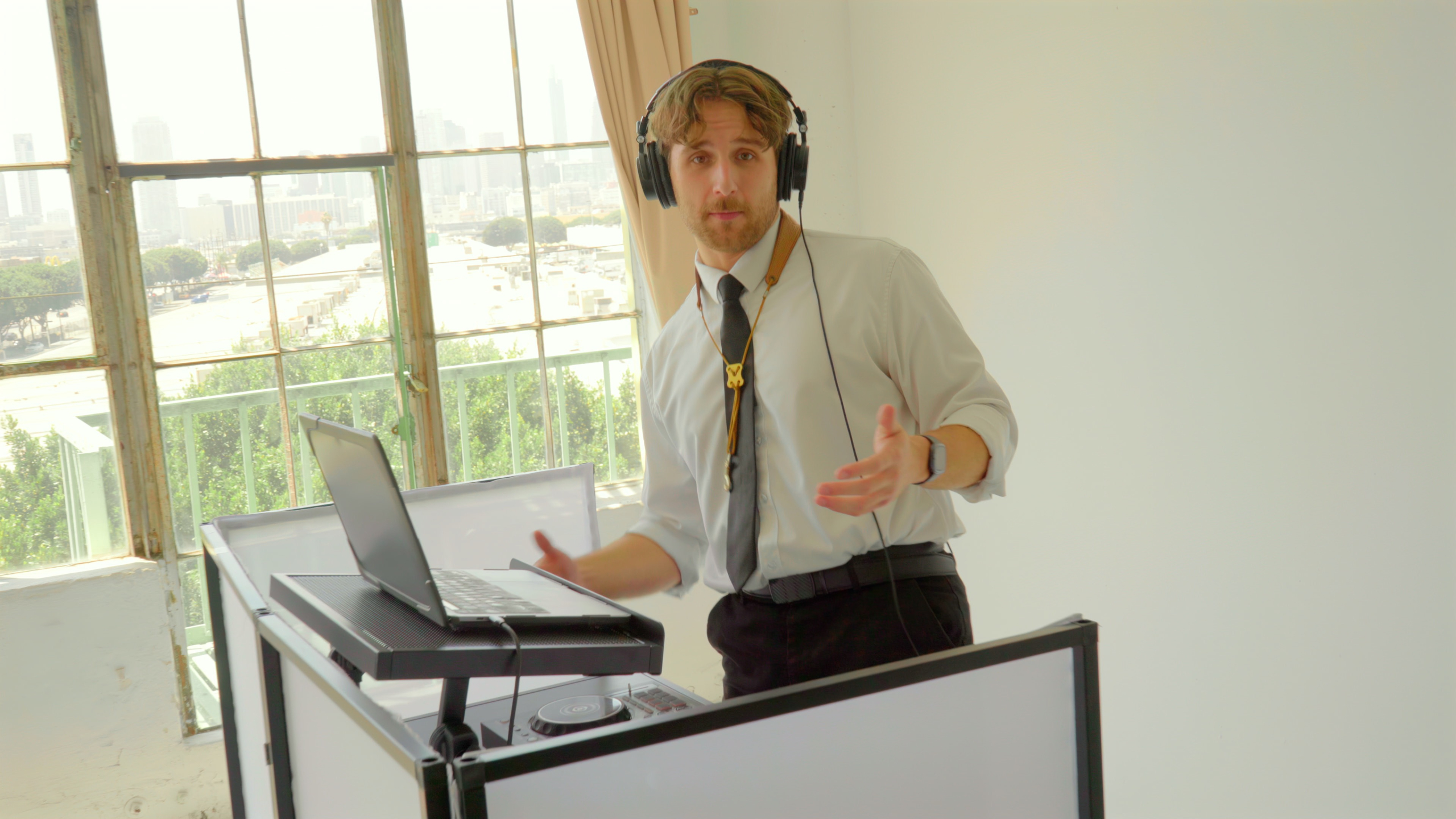 Chris wearing headphones at a DJ booth in a bright Los Angeles event space