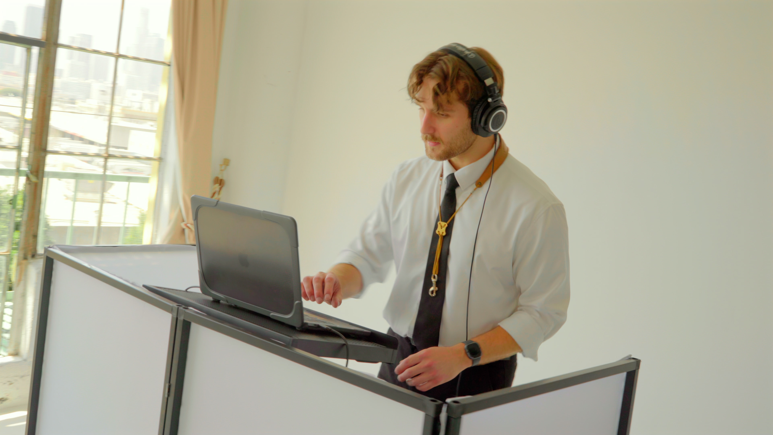 Chris standing at a DJ booth with headphones during a Los Angeles event setup