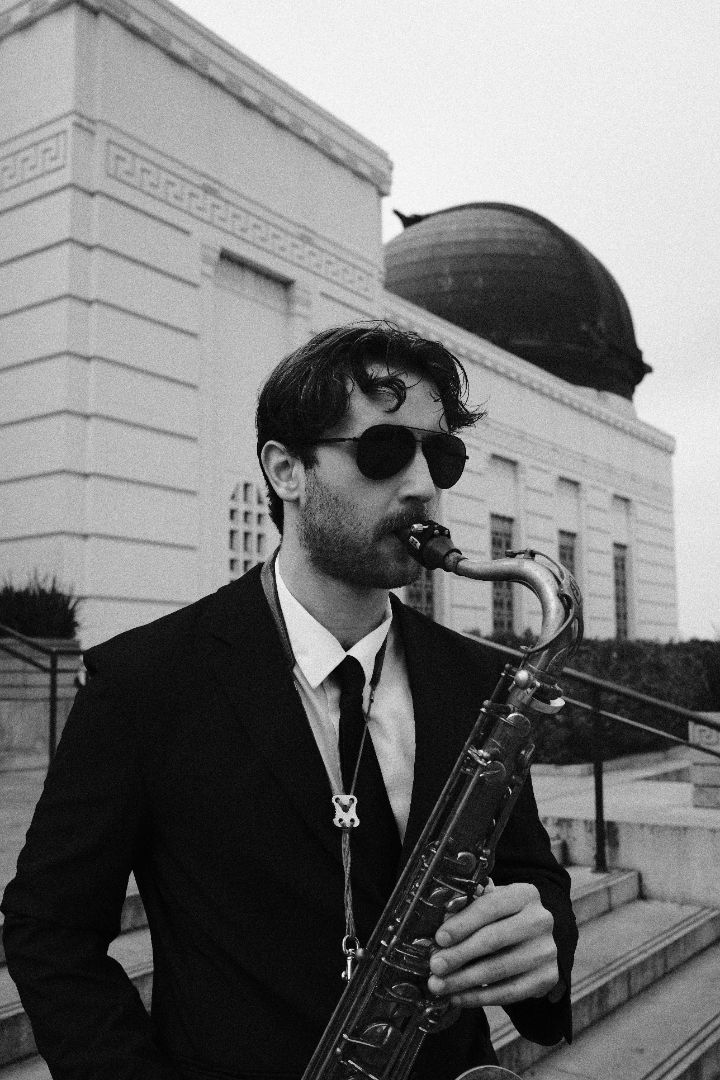 Black and white portrait of Chris playing saxophone outdoors in Los Angeles